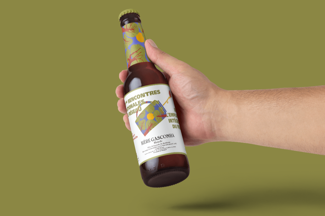 DFCI - Bonnet Margot - hand-holding-amber-glass-beer-bottle-mockup-template